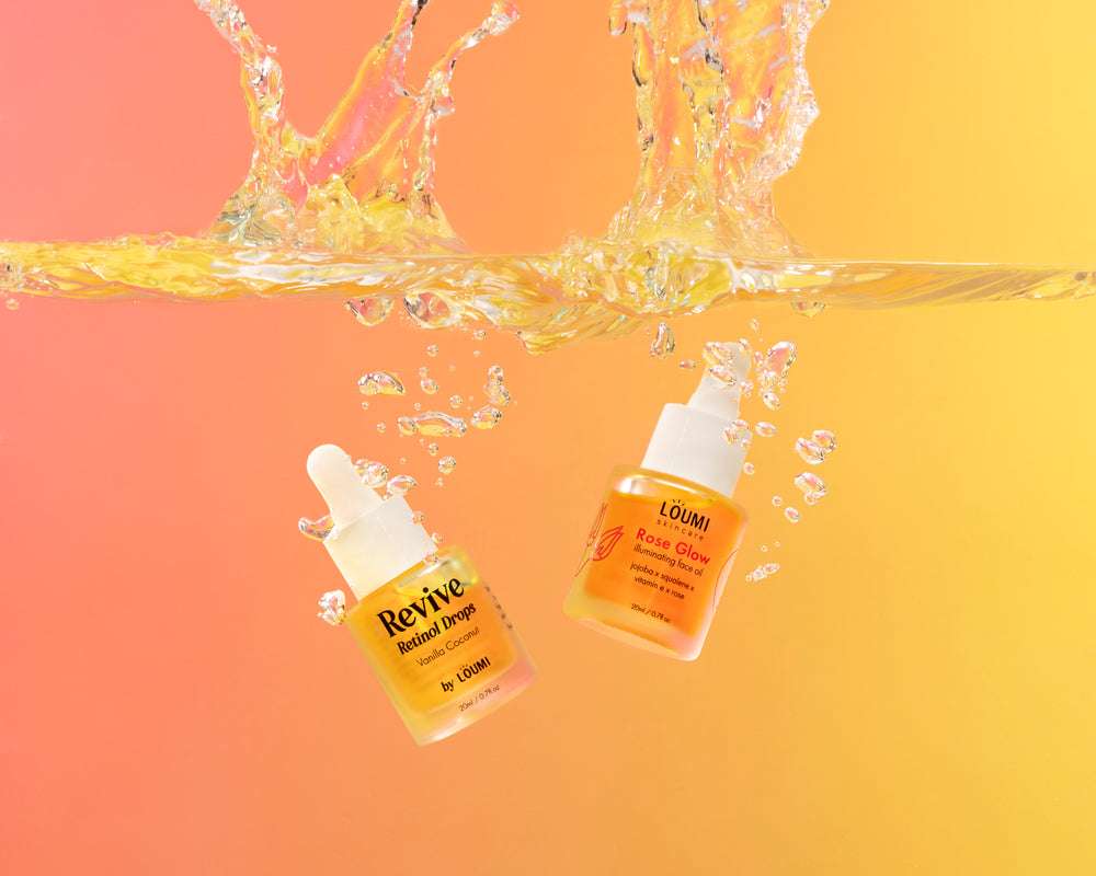 the retinol drops and rose glow oil being dropped in water against an orange background